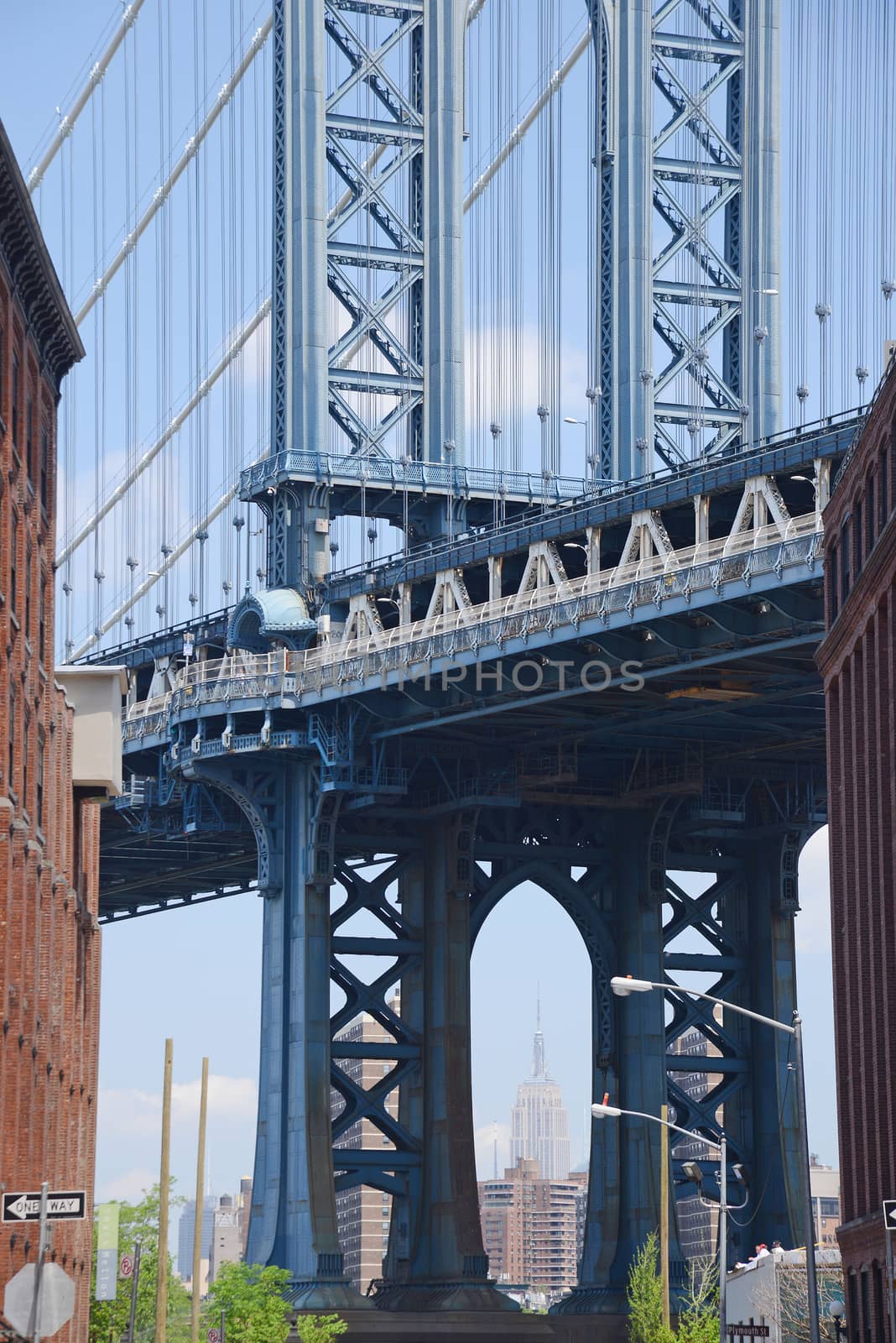 east tower of manhattan bridge framed with old building in brooklyn