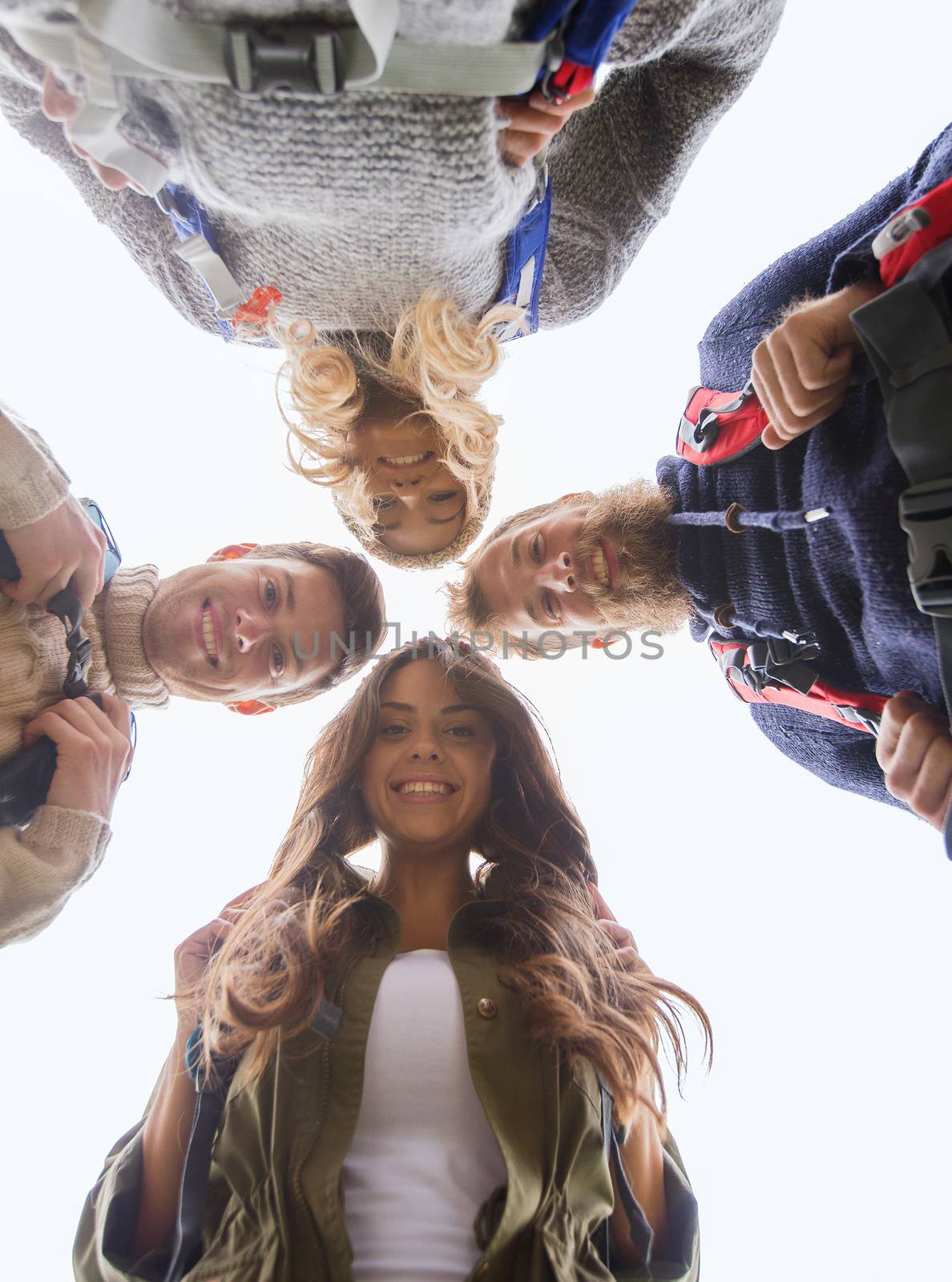 group of smiling friends with backpacks hiking by dolgachov