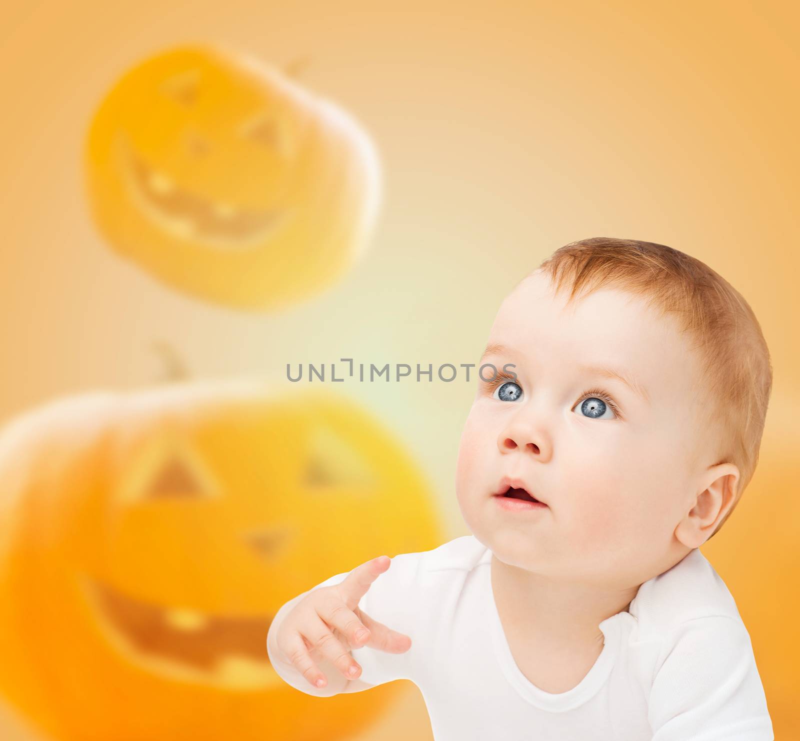 smiling baby over pumpkins background by dolgachov