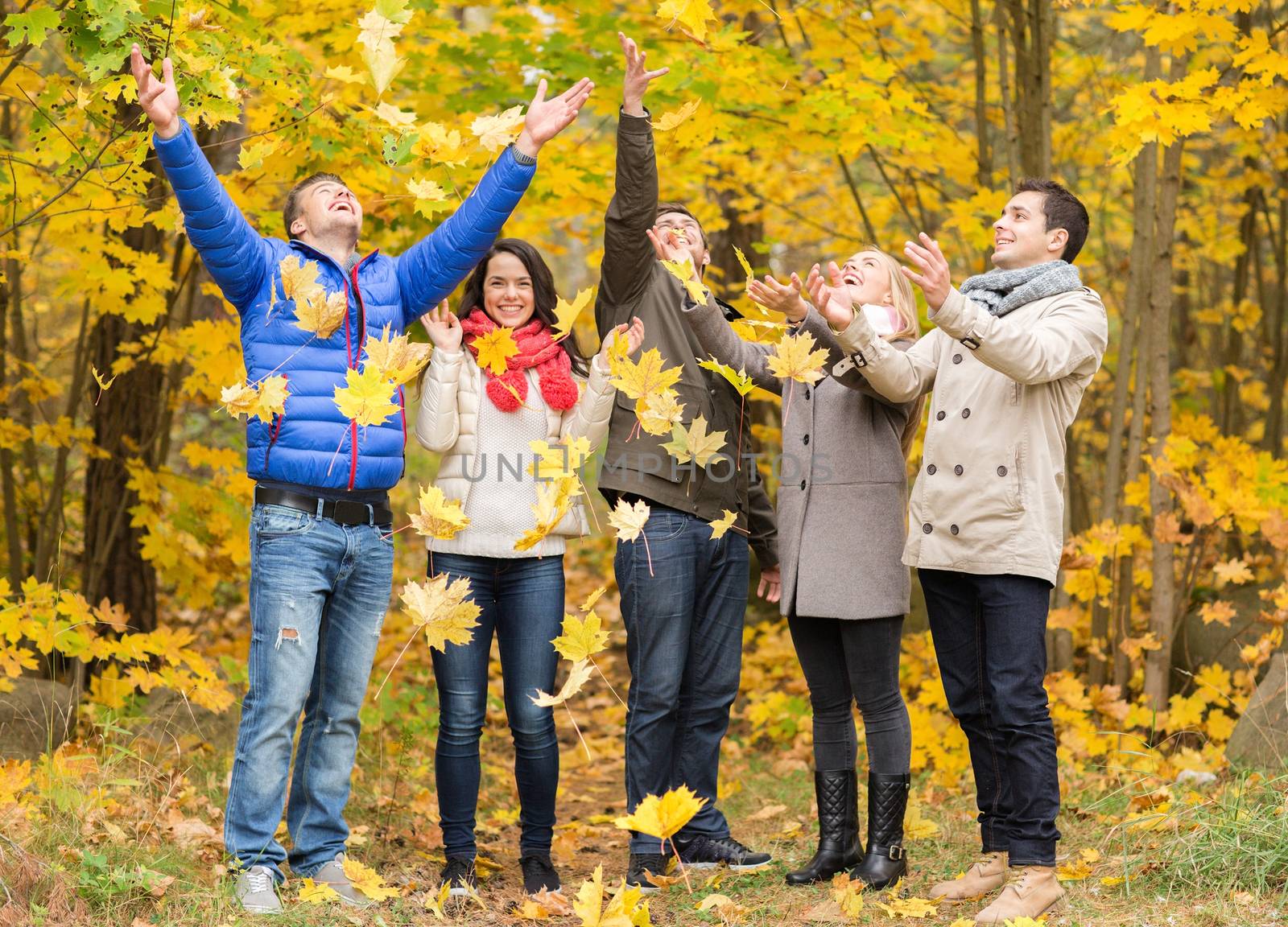 group of smiling men and women in autumn park by dolgachov