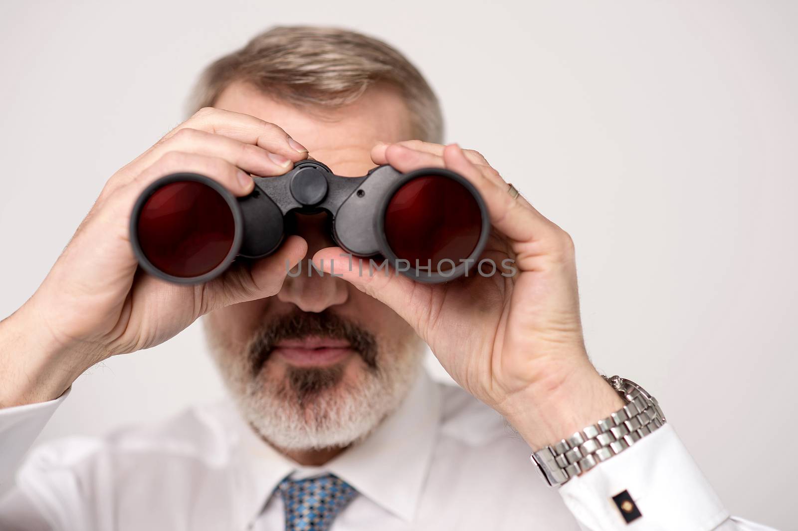 Image of a elder businessman observing through binoculars