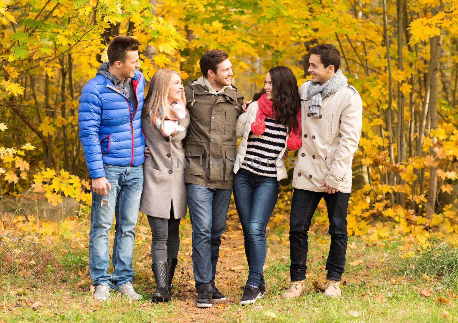 group of smiling men and women in autumn park by dolgachov