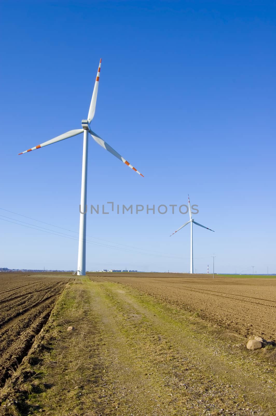 Windmill conceptual image. Windmills on the plowed field.