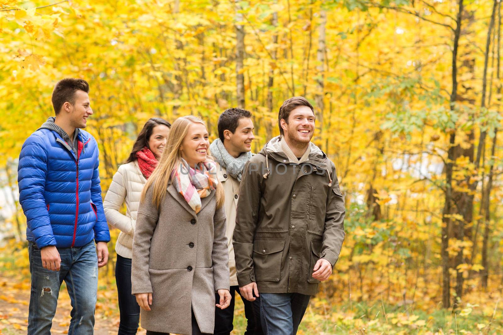 love, relationship, season, friendship and people concept - group of smiling men and women walking in autumn park