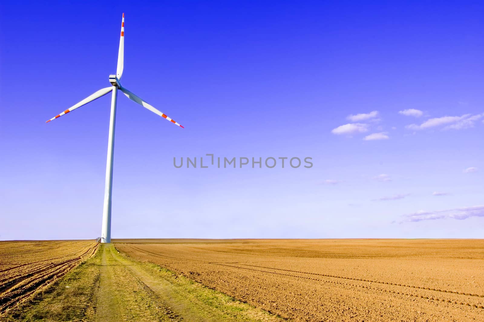 Windmill conceptual image. Windmills on plowed field.