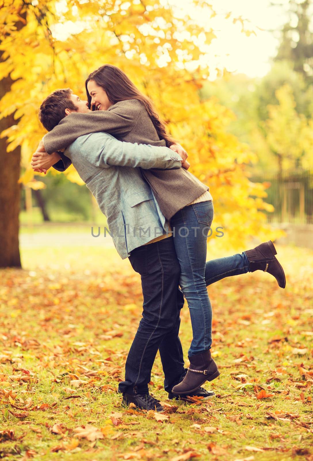 holidays, love, travel, relationship and dating concept - romantic couple playing in the autumn park