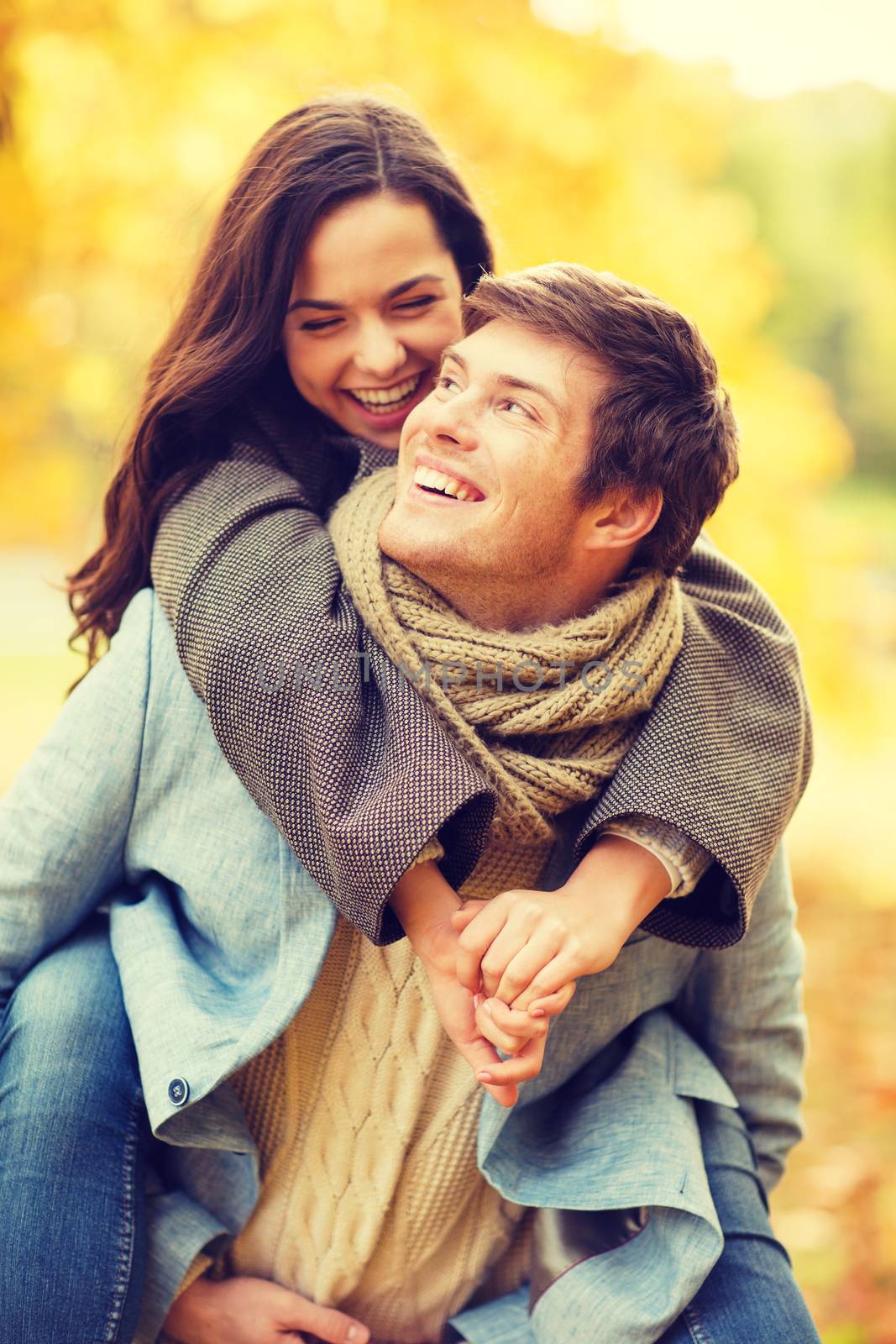 holidays, love, travel, relationship and dating concept - romantic couple playing in the autumn park