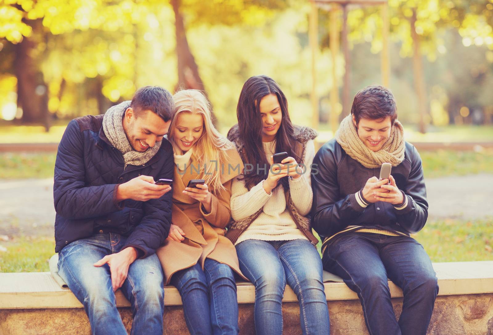 summer, holidays, vacation, happy people concept - group of friends or couples with smartphones having fun in autumn park