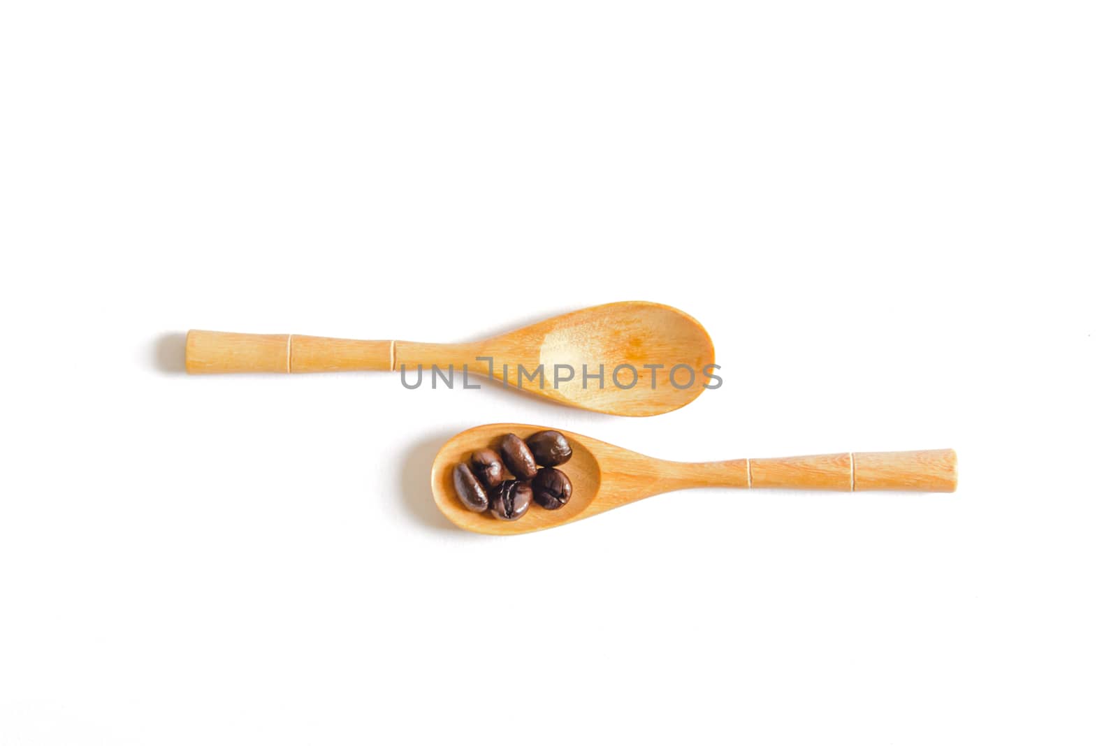 Coffee beans on wooden spoon isolated on white background.