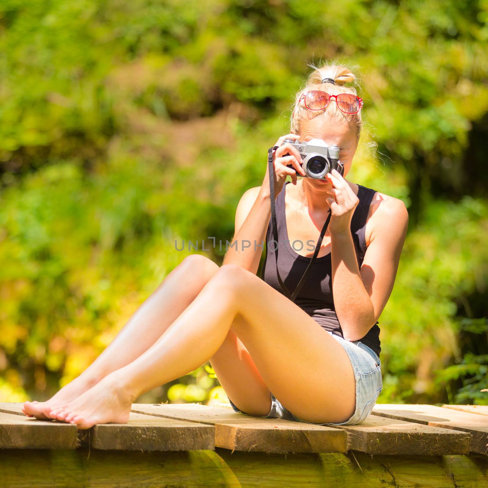 Woman in nature with retro camera. by kasto