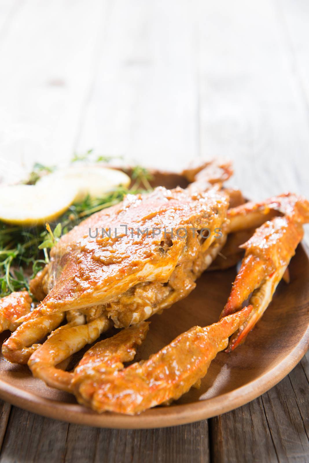 Close up cooked delicious hot and spicy sauce blue crab, on wooden background. Fresh cook with hot smoke steams.
