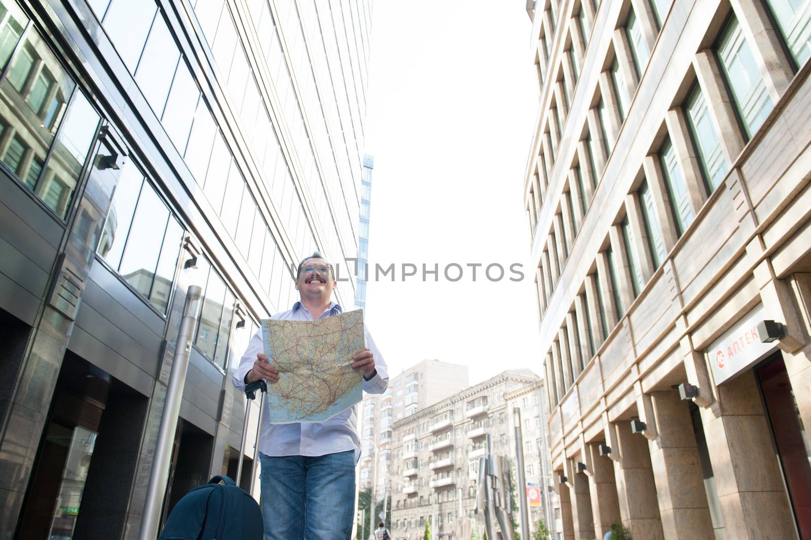 Man with blue bag lookig the way by city plan