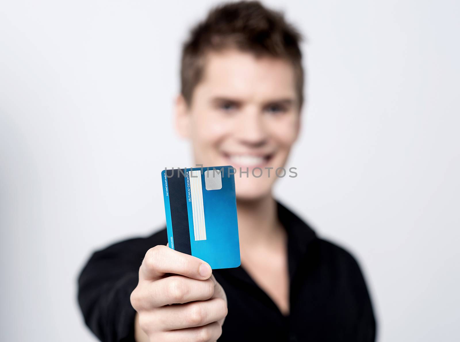 Young male showing his credit card to camera