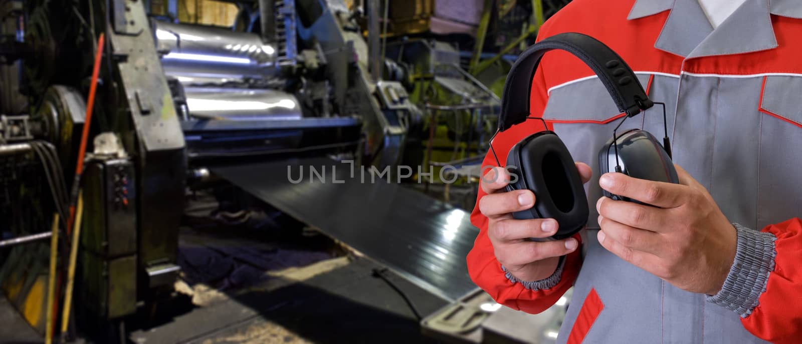 Worker with protective headphone at man hands at industrial factory