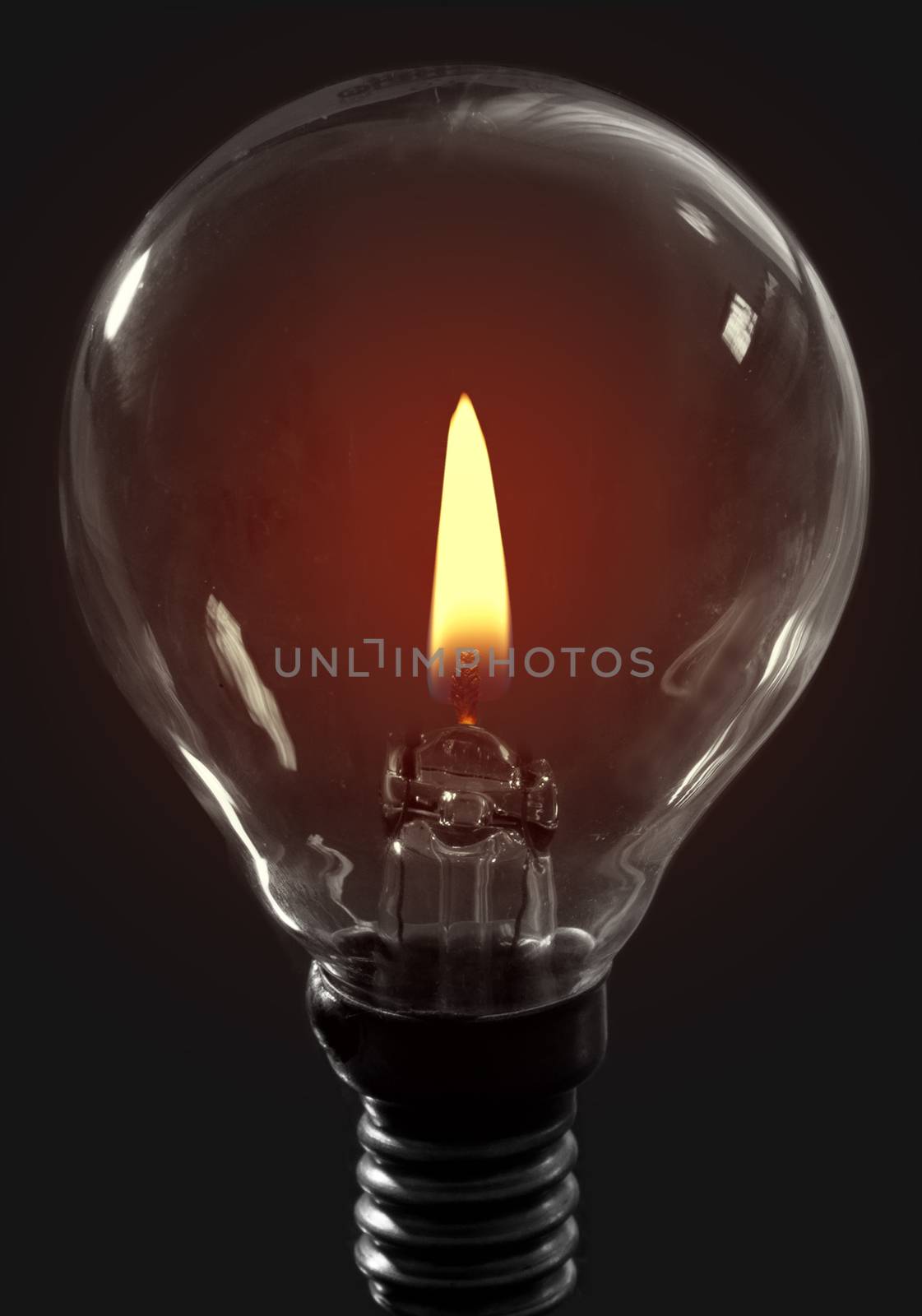 Glowing candle flame inside a light bulb 