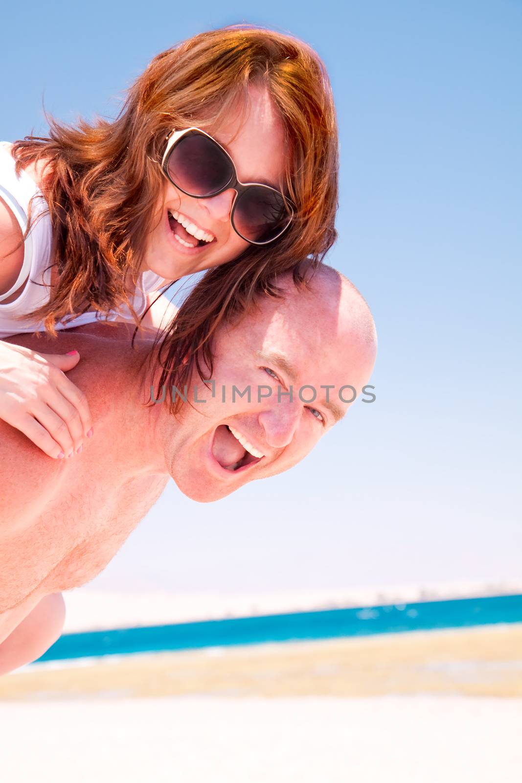 Happy couple having fun on the sunny beach
