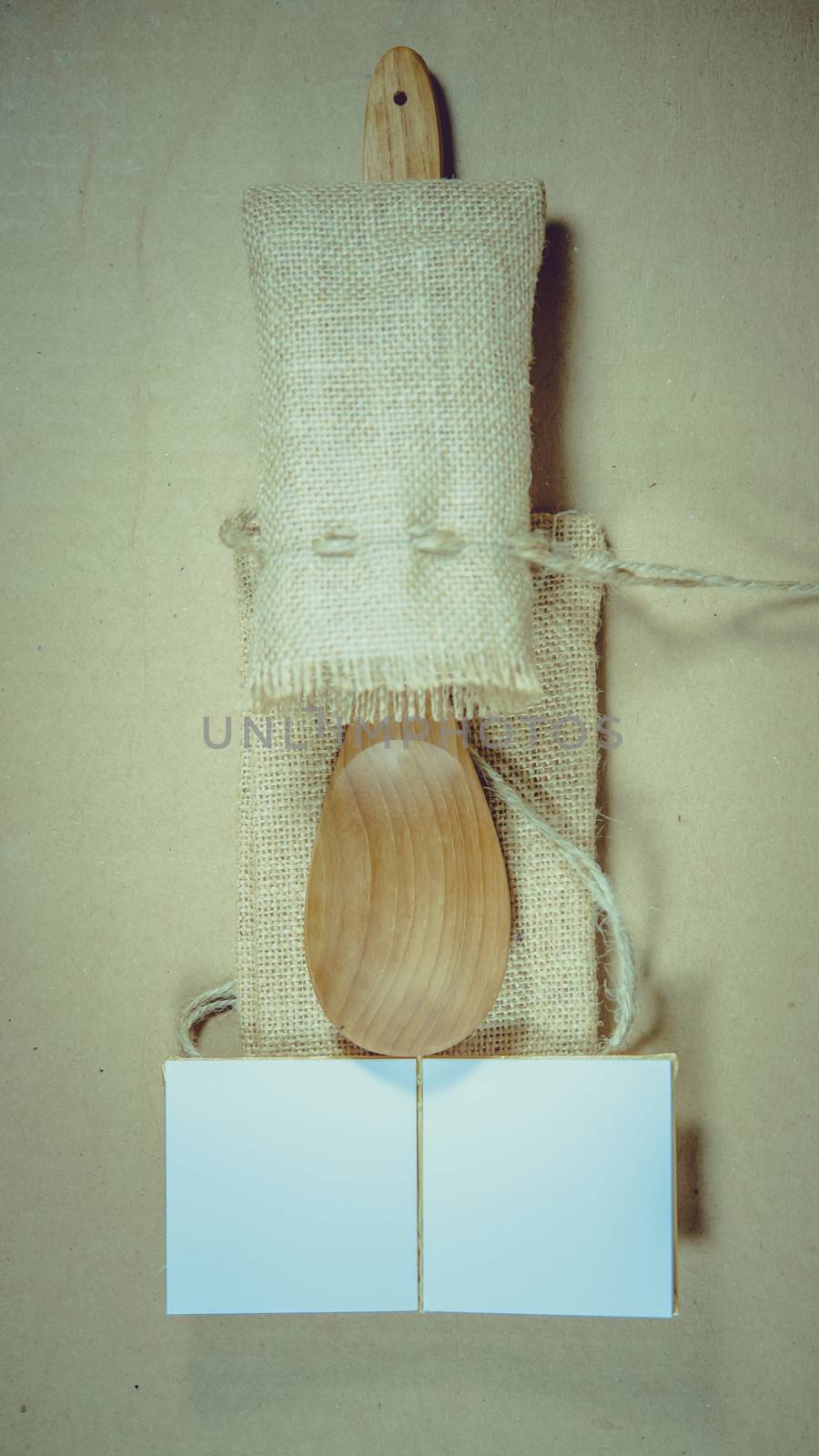 Notepad and wooden spoon on sack surface background.