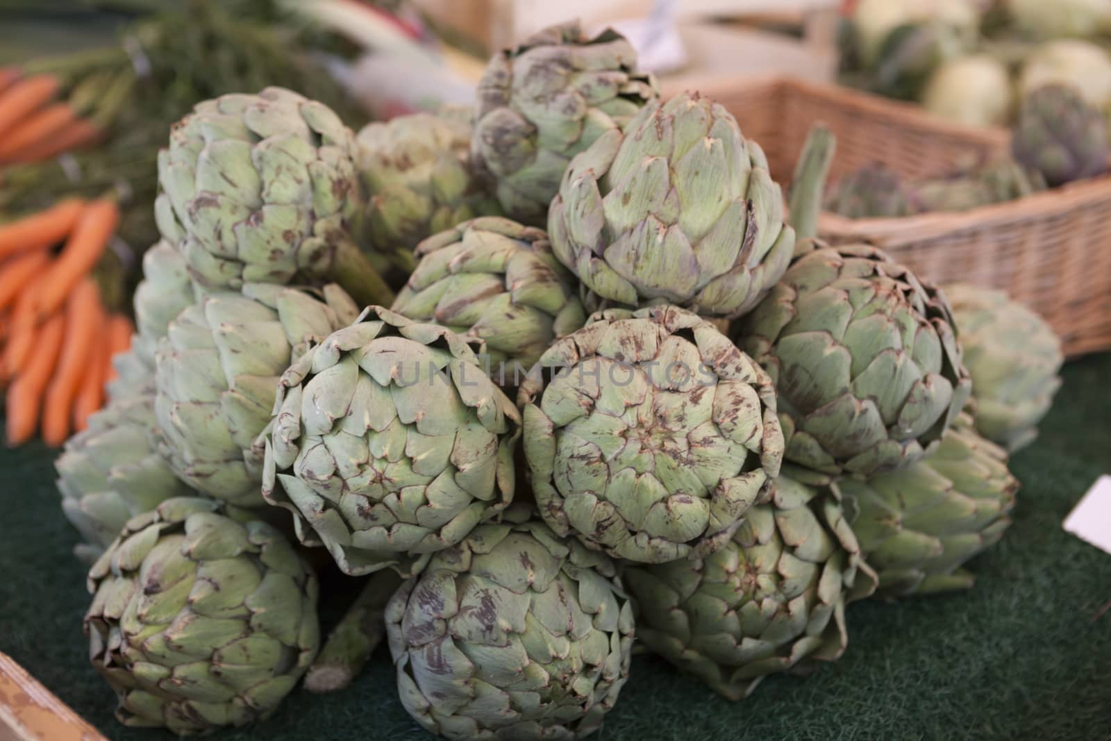 Fresh fruits artichokes at the farmers market by mcherevan