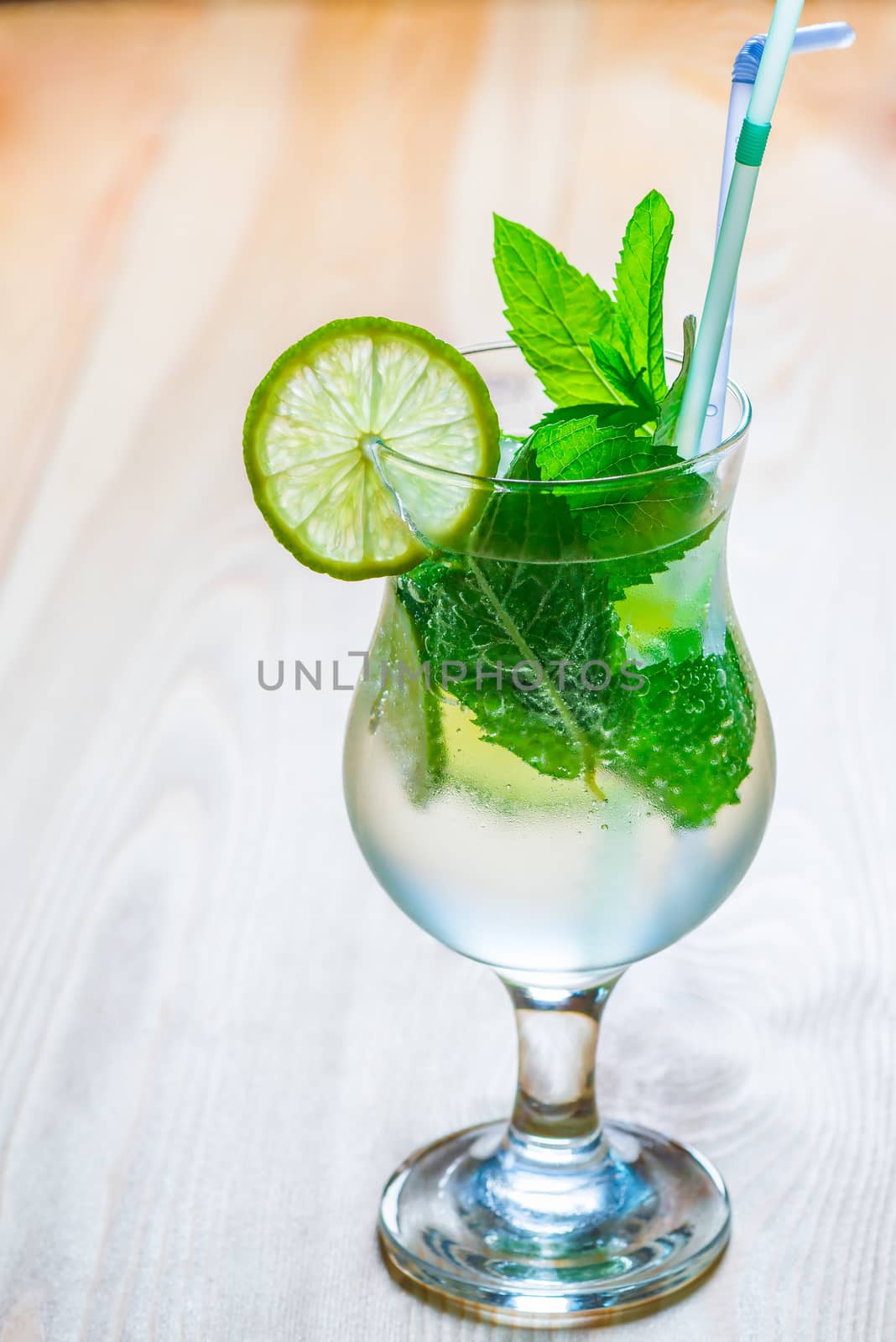 glass of cool mojito on a wooden table by kosmsos111