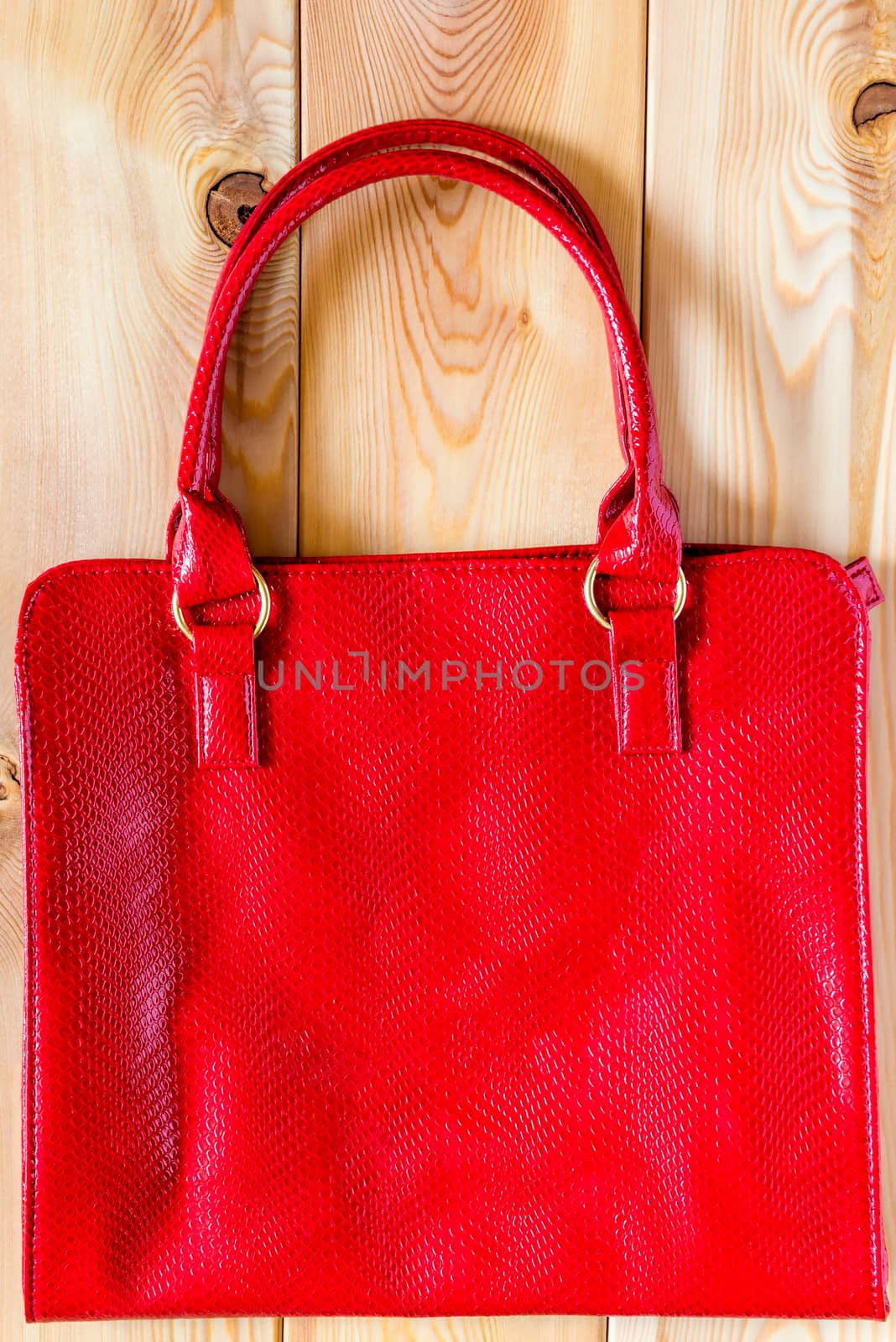 Female red bag from a genuine leather on a wooden background by kosmsos111