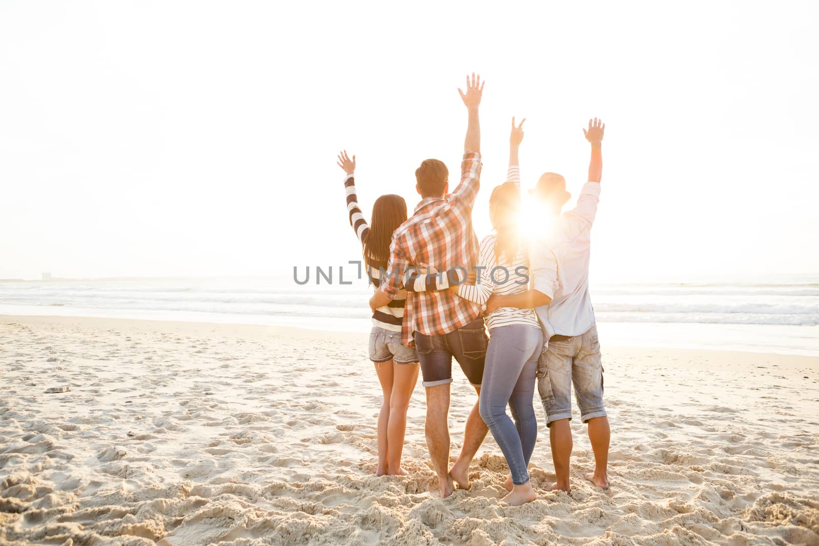 Group of friends at the beach and watching the sunset