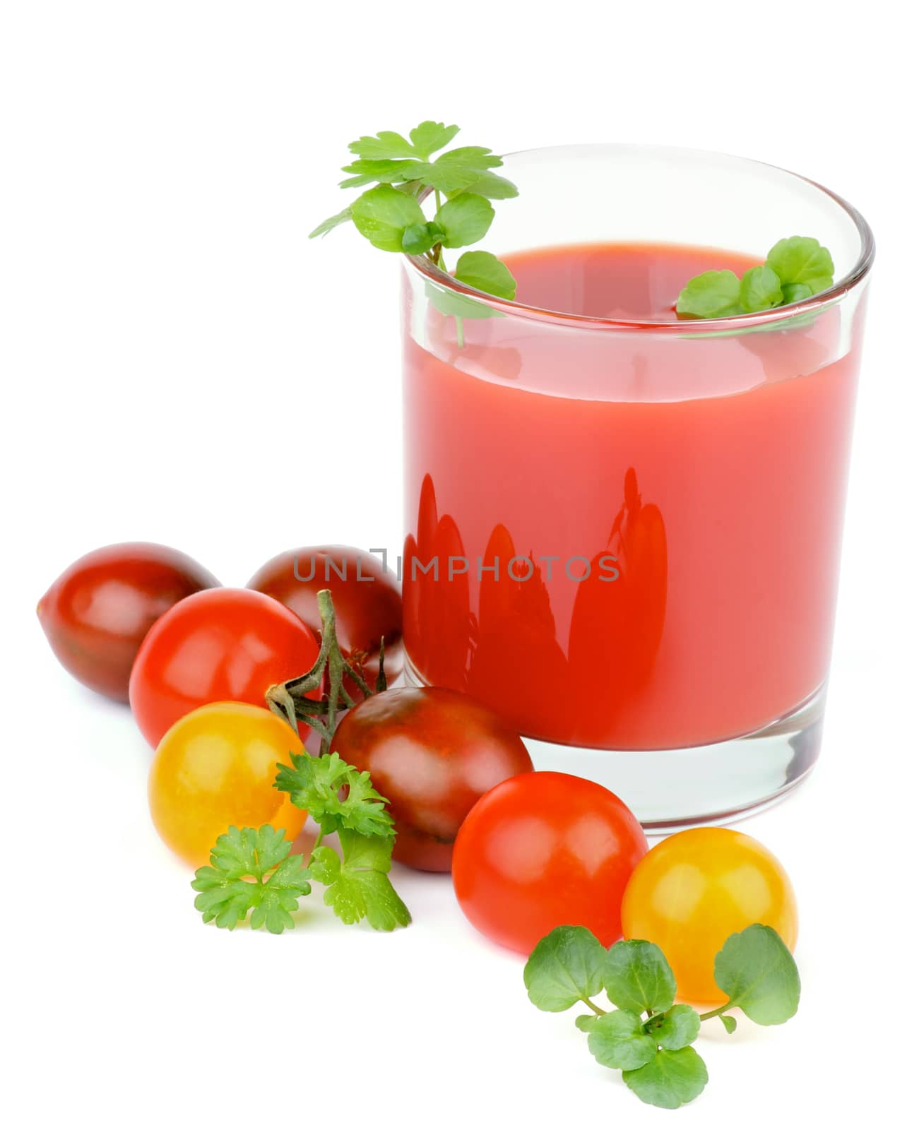 Glass of Tomato Juice and Heap of Brown, Yellow and Red Tomatoes with Parsley and Watercress closeup on White background