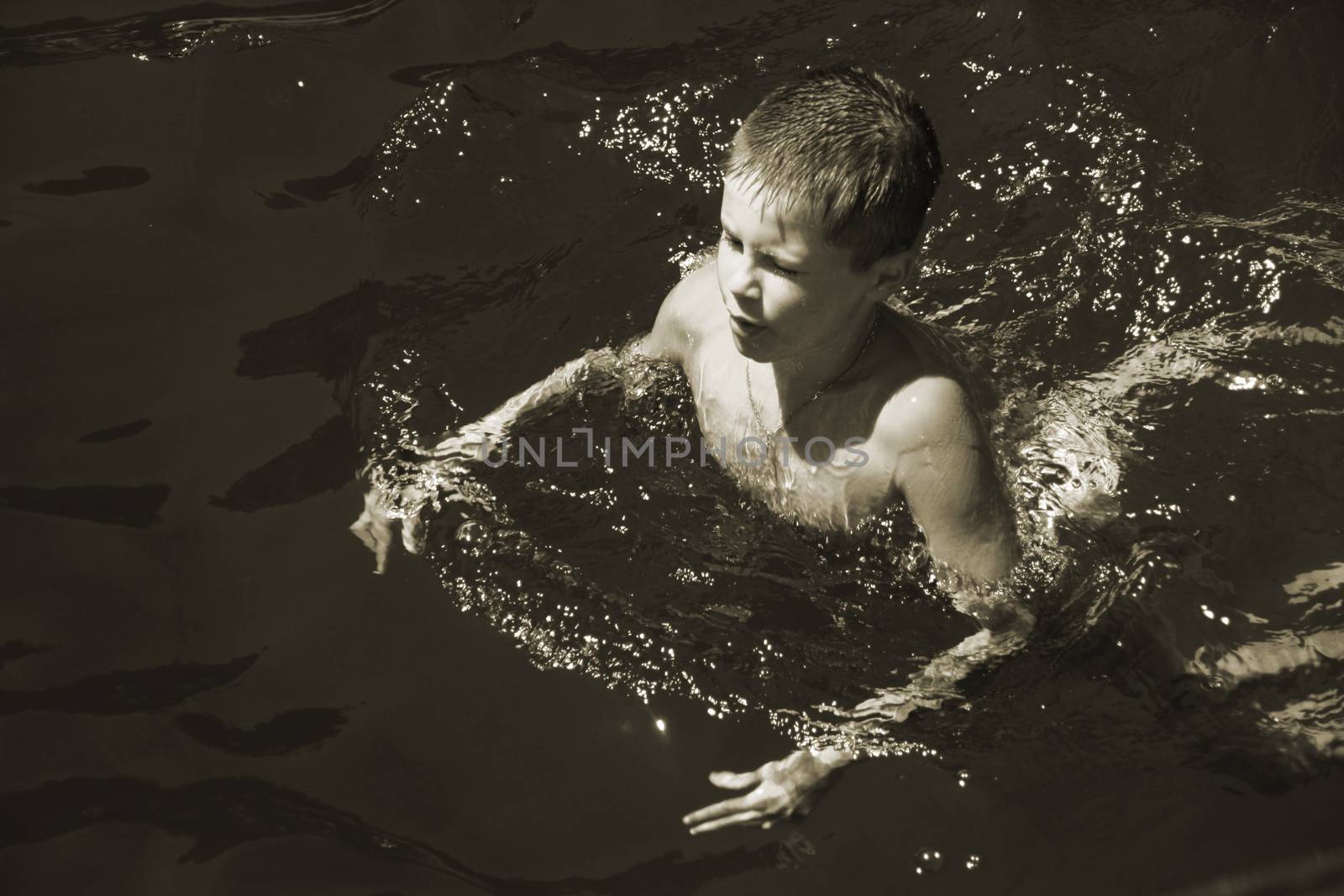 Close up of young boy swimming  by alexx60