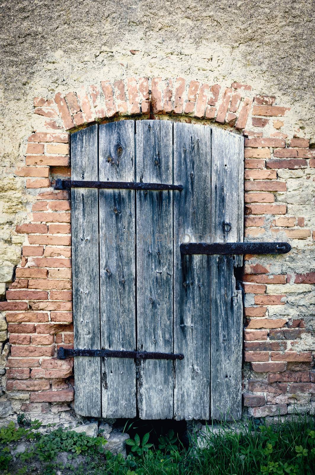 Wooden door of an old abandoned brick building