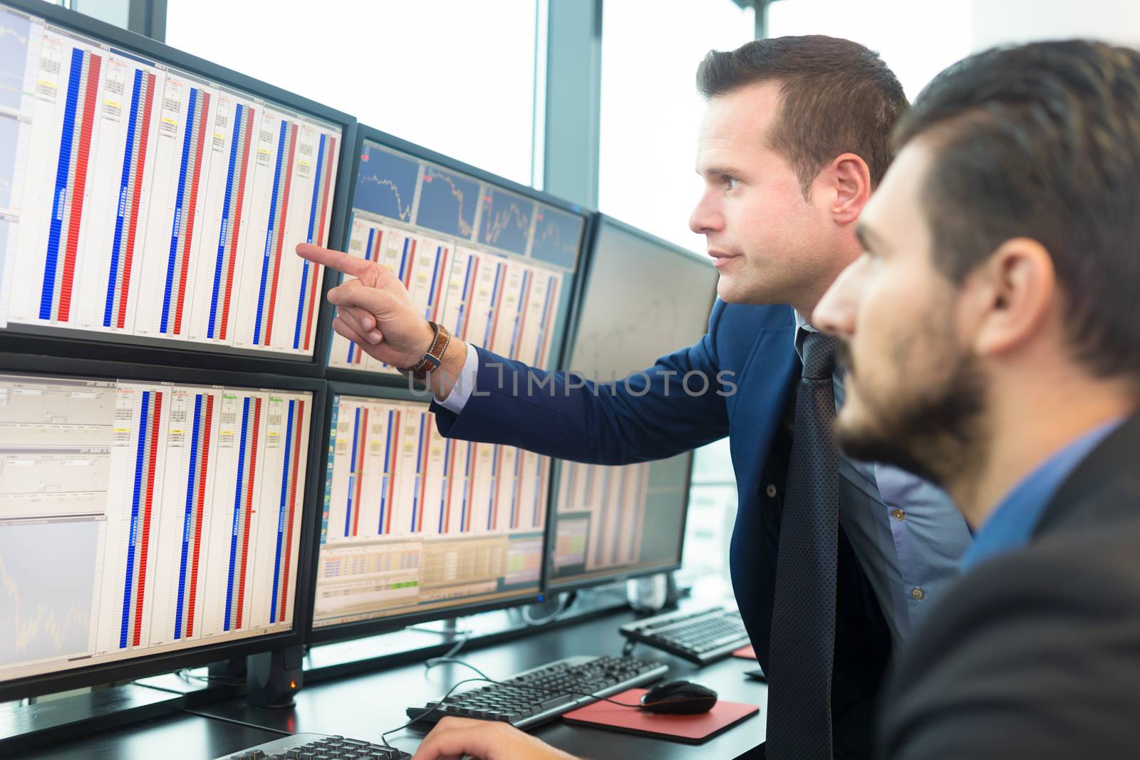Stock traders looking at computer screens. by kasto