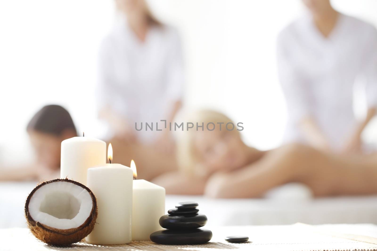 Spa massage tools and women getting massage on background