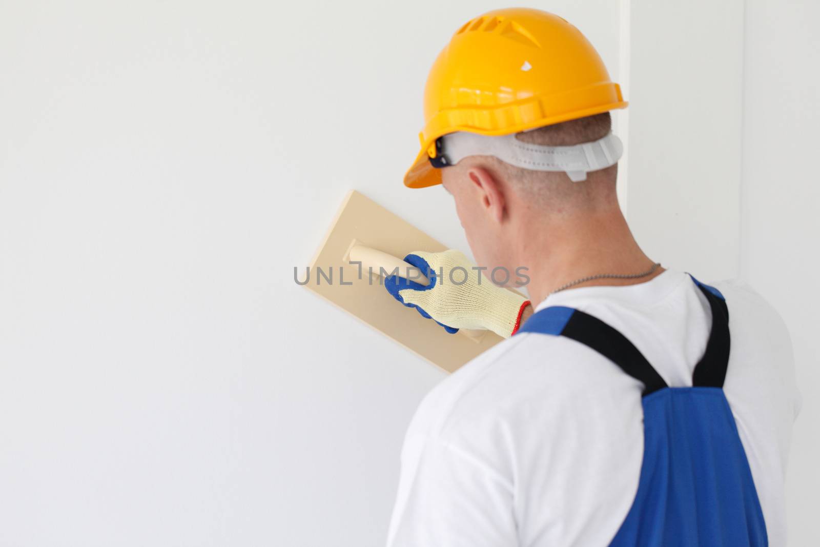 portrait of workman polishing wall