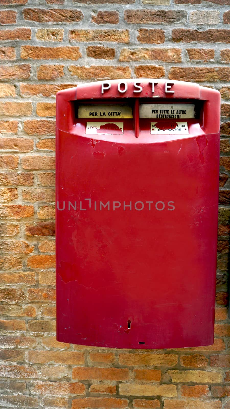 red postal box public on brick wall in Venice, Italy