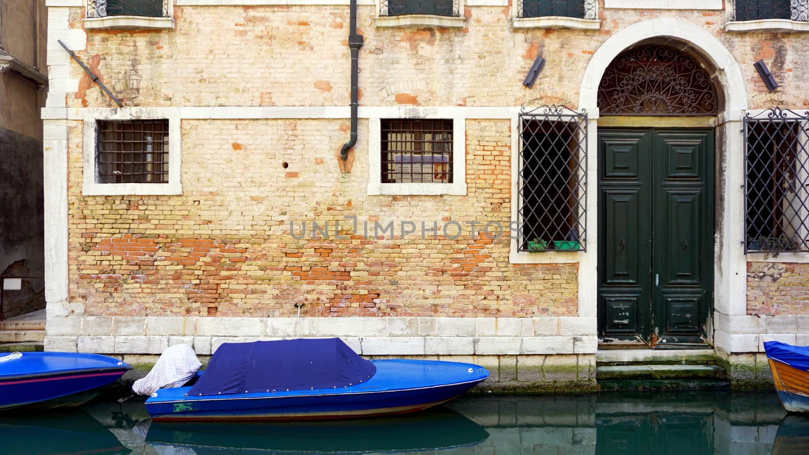 canal and boats with ancient brick wall house in Venice, Italy