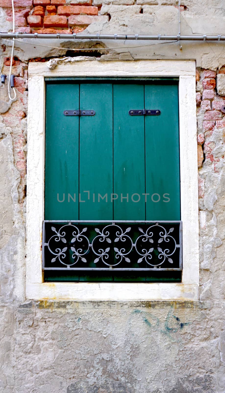 green Window on old brick wall building architecture, Venice, Italy
