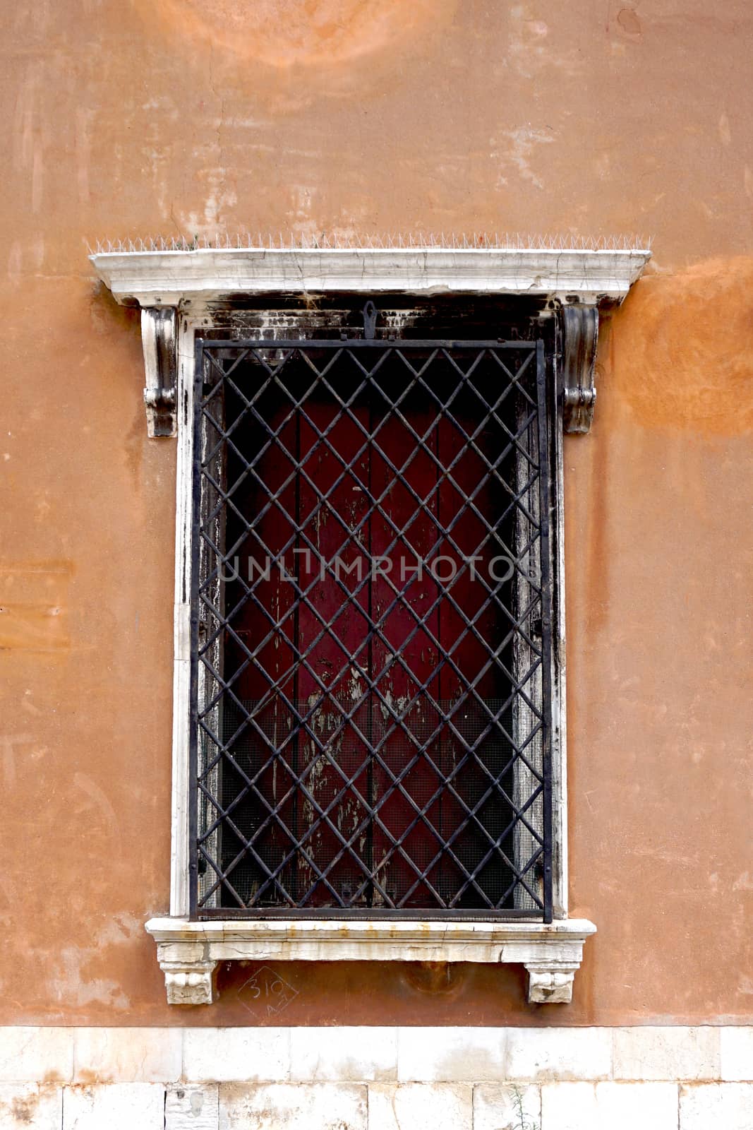 old window with metal frame of old house building in Venice, Italy