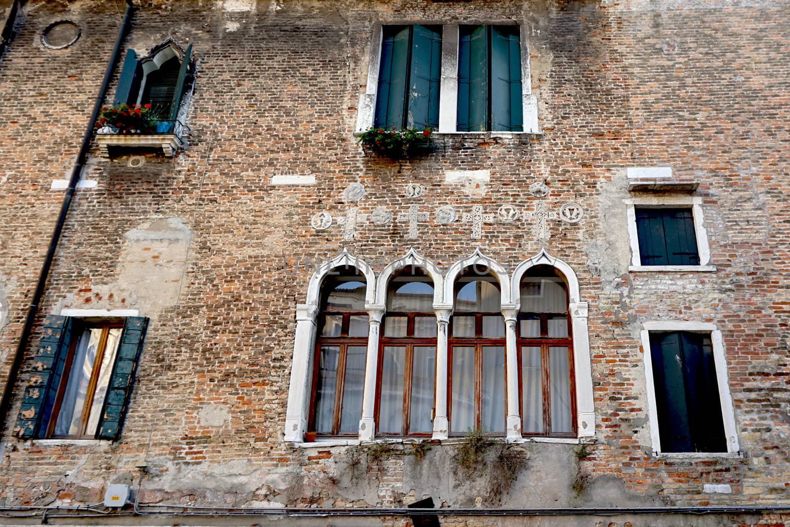 Windows mixed on brick wall building  by polarbearstudio