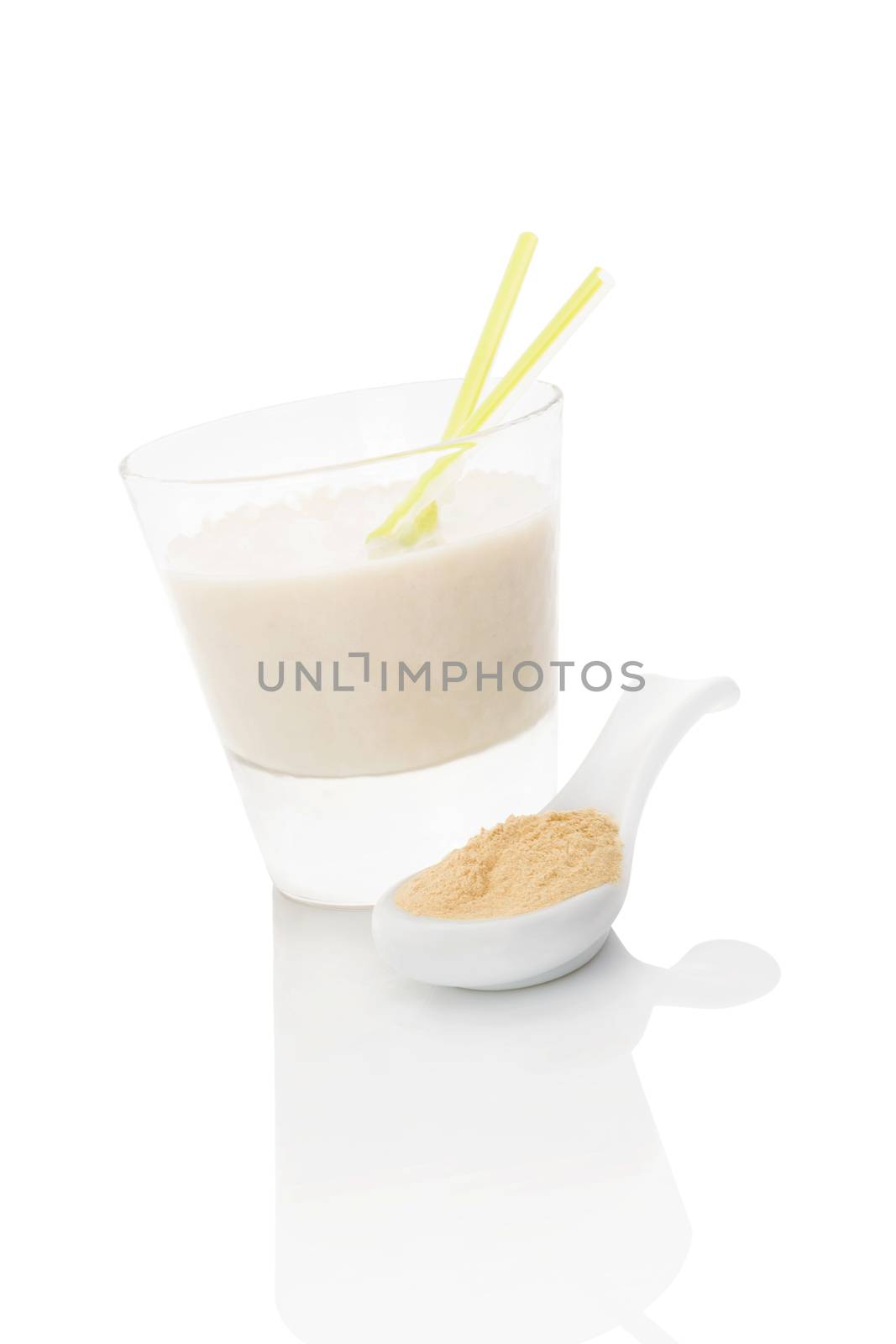 Maca powder on spoon and maca milkshake in glass isolated on white background. Natural alternative medicine.