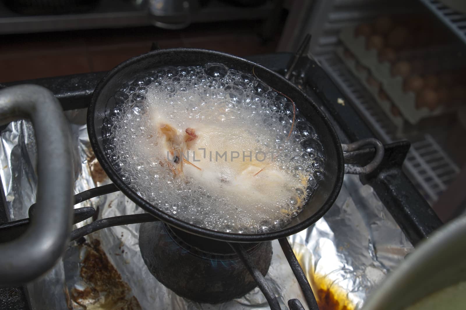 shrimps boil in pan on restaurant kitchen