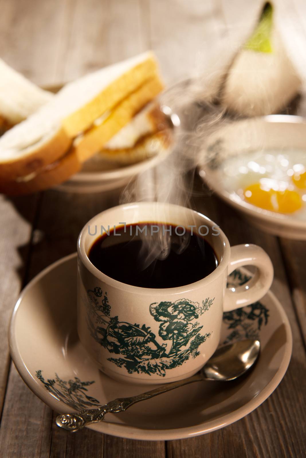 Traditional kopitiam style Malaysian coffee and breakfast with morning sunlight. Fractal on the cup is generic print. Soft focus dramatic ambient light over wood table.