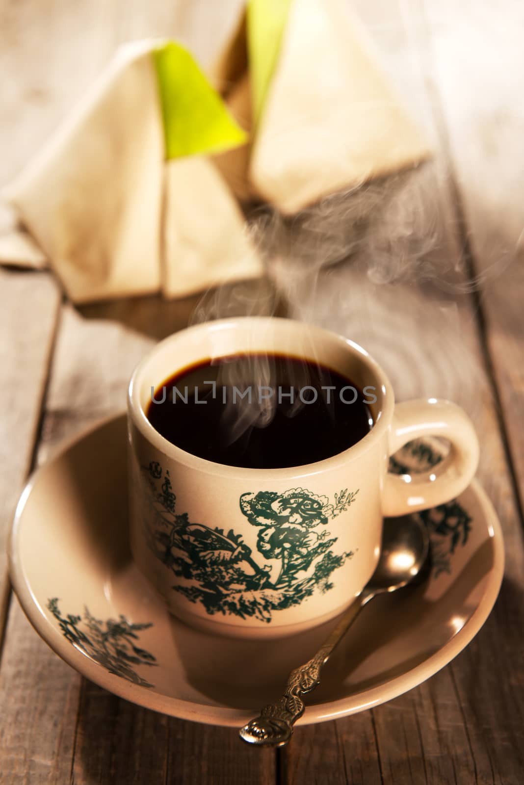 Traditional kopitiam style Malaysian coffee in vintage mug and saucer and nasi lemak. Fractal on the cup is generic print. Soft focus dramatic ambient light over wood table.
