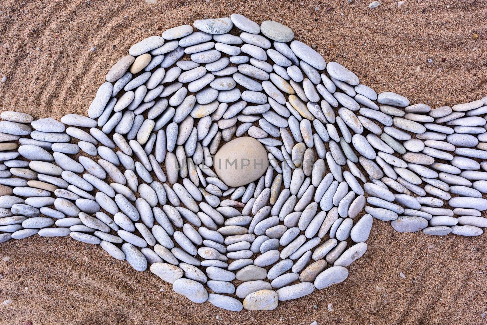 Twisting of stones on a sandy beach