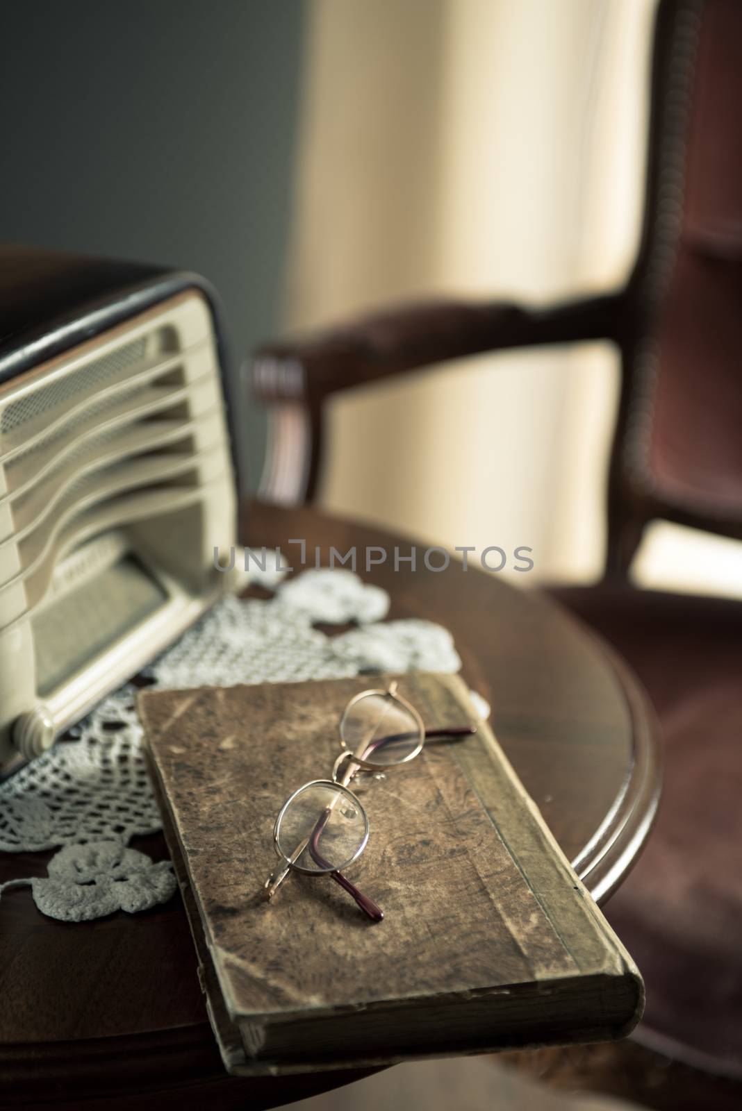 Vintage home interior with old radio and book on round wooden table.