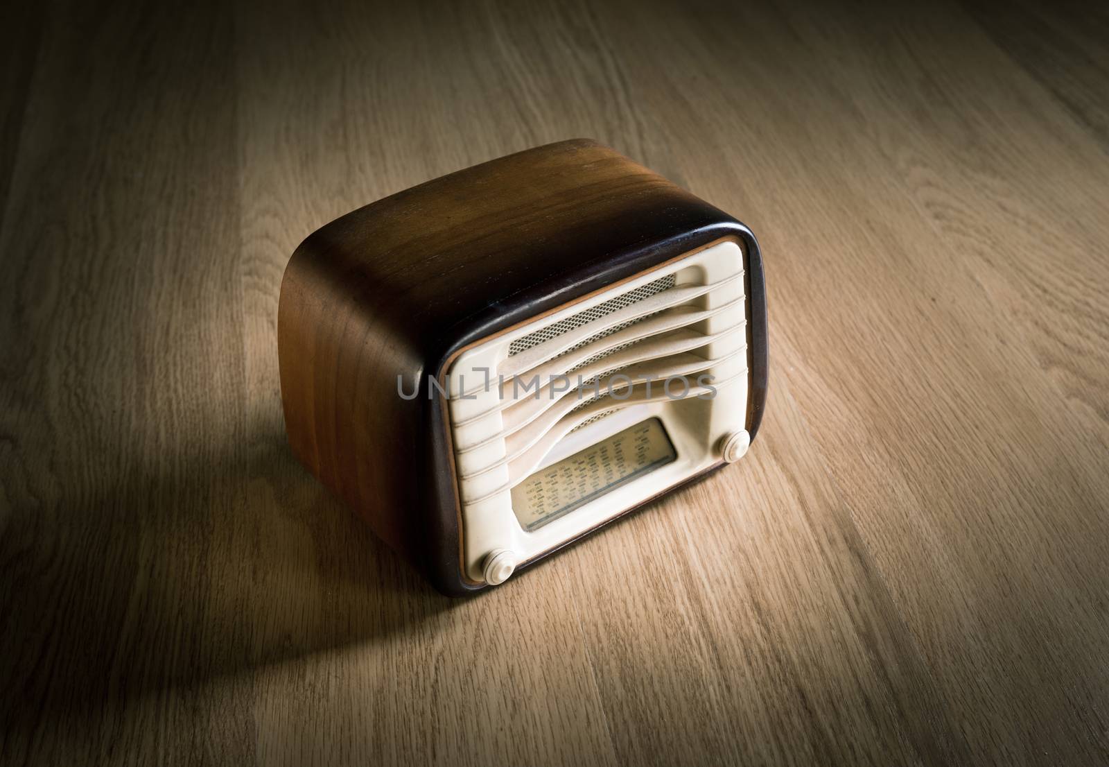 Vintage shiny wooden radio on a wooden desk.