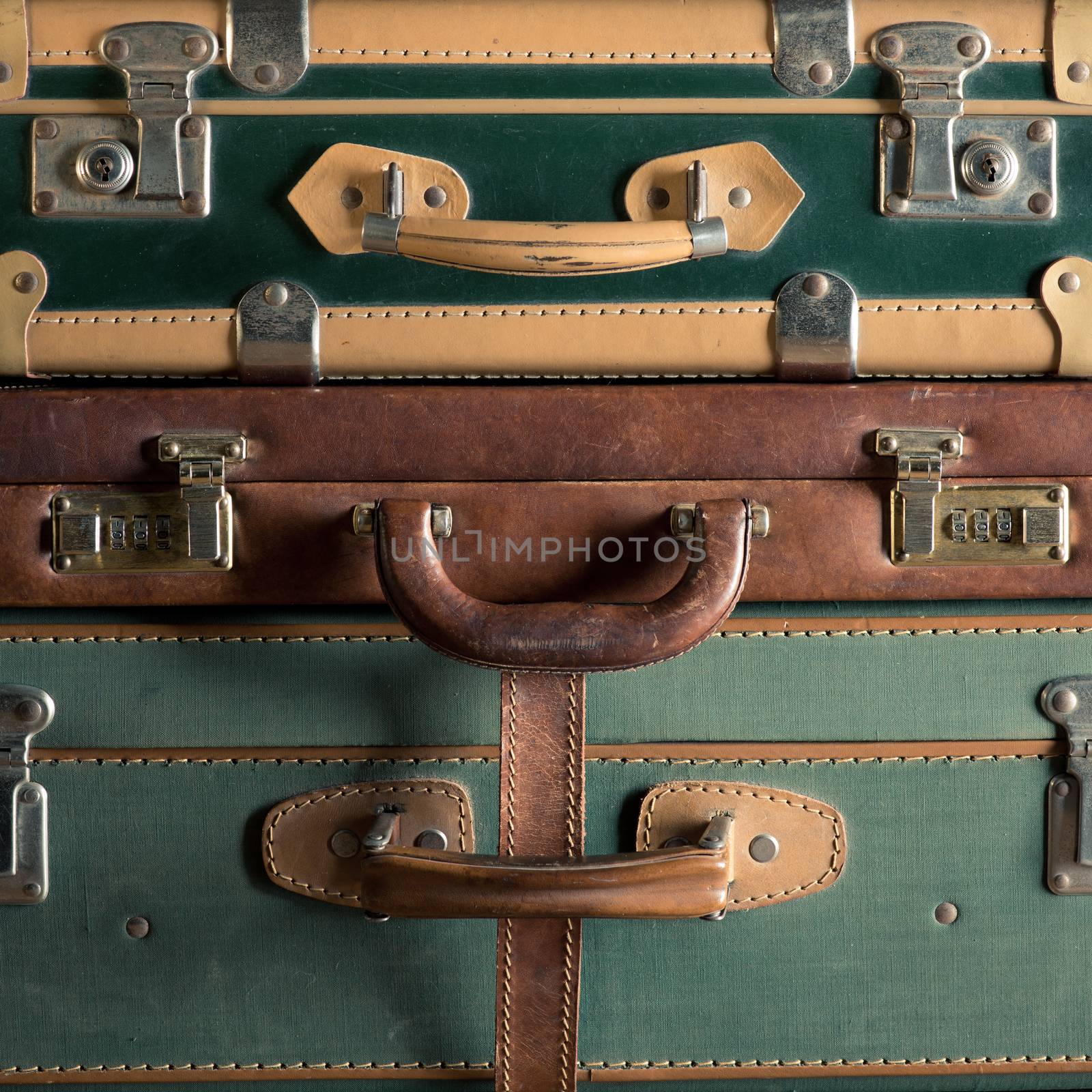 Stack of colorful vintage suitcases, handles close up, travelling concept.