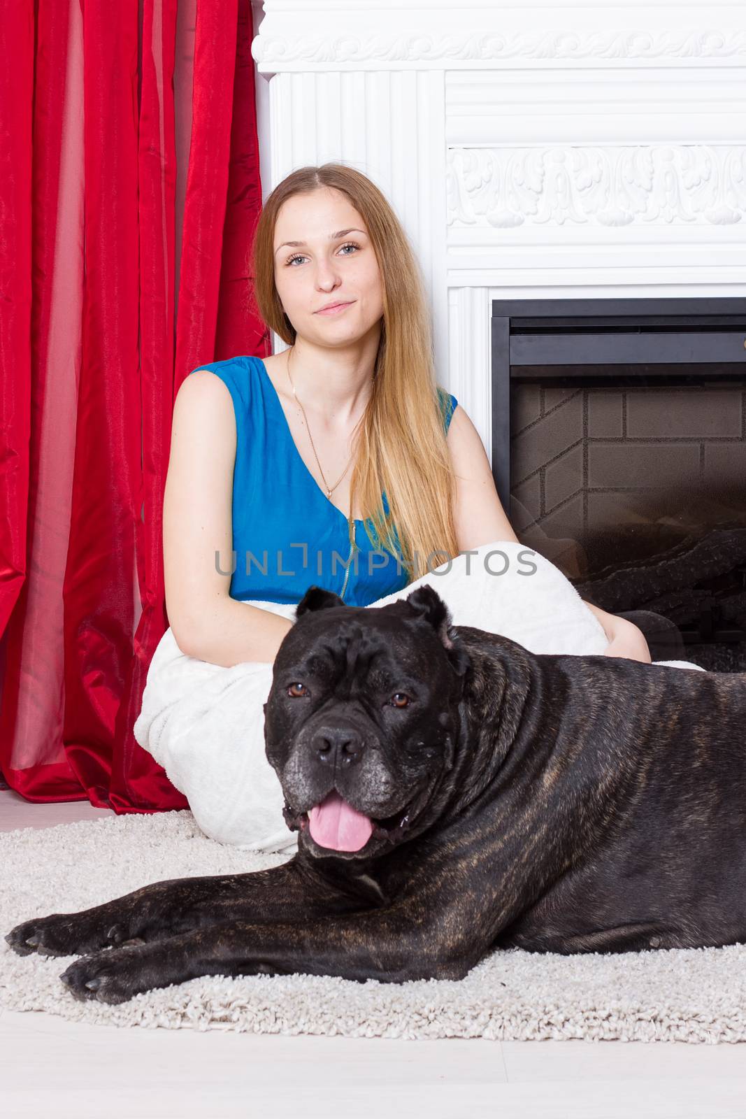 Girl in blue dress sitting by the fireplace with dog Cane Corso by victosha