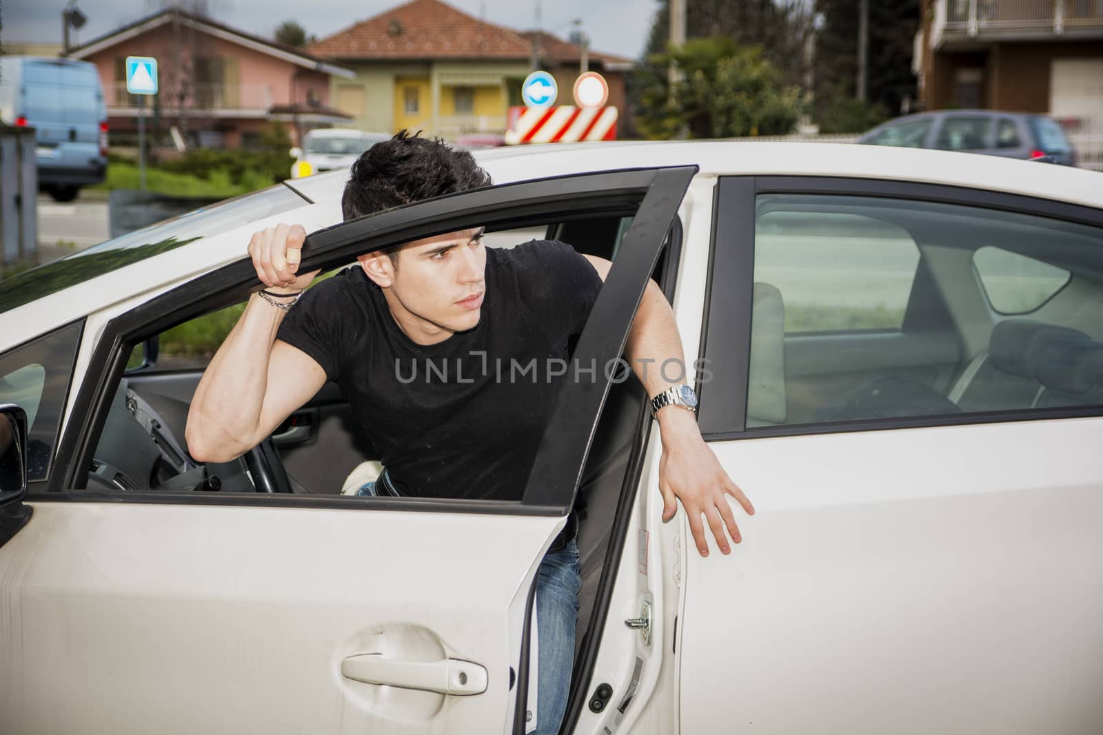 Young man getting out of white car by artofphoto