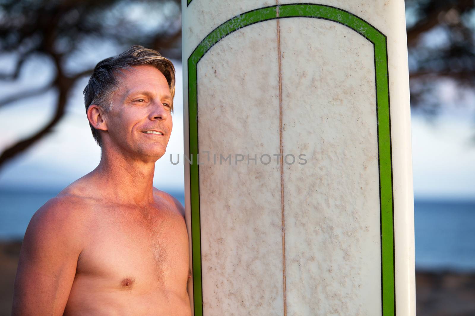 Single confident white male holding surfboard outdoors