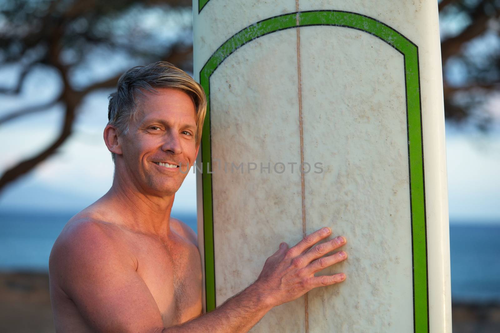 Hopeful single adult outdoors holding a surfboard