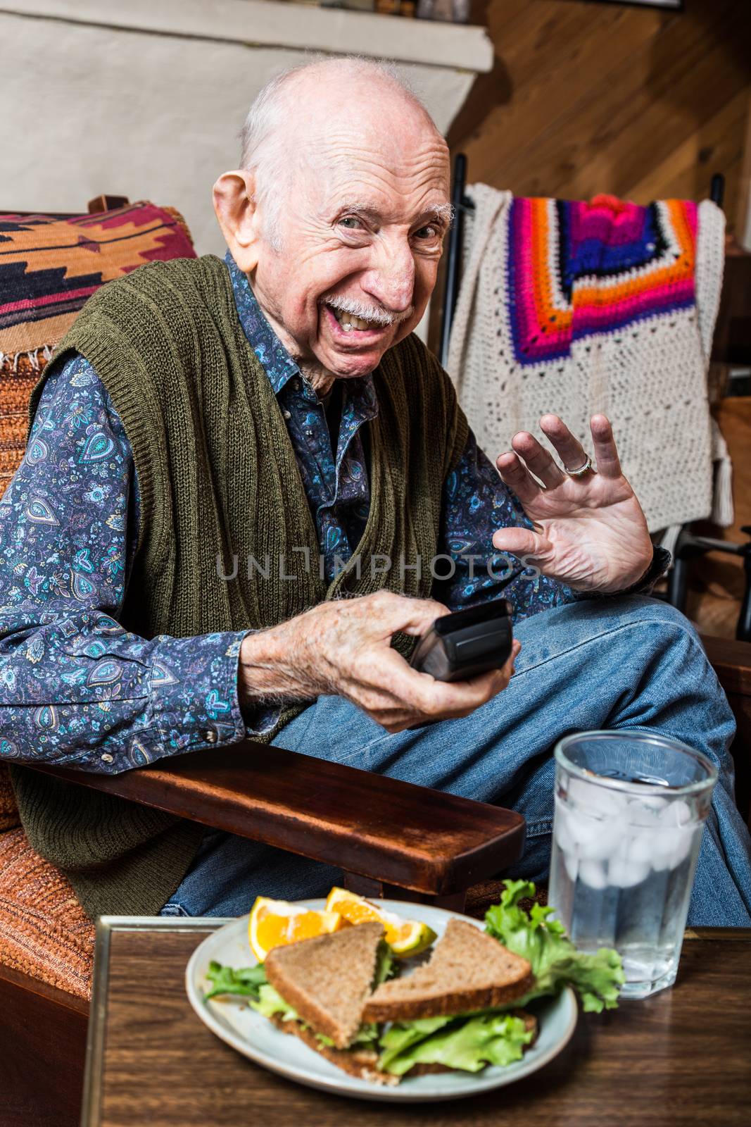 Grumpy elderly man with sandwich on sidetable
