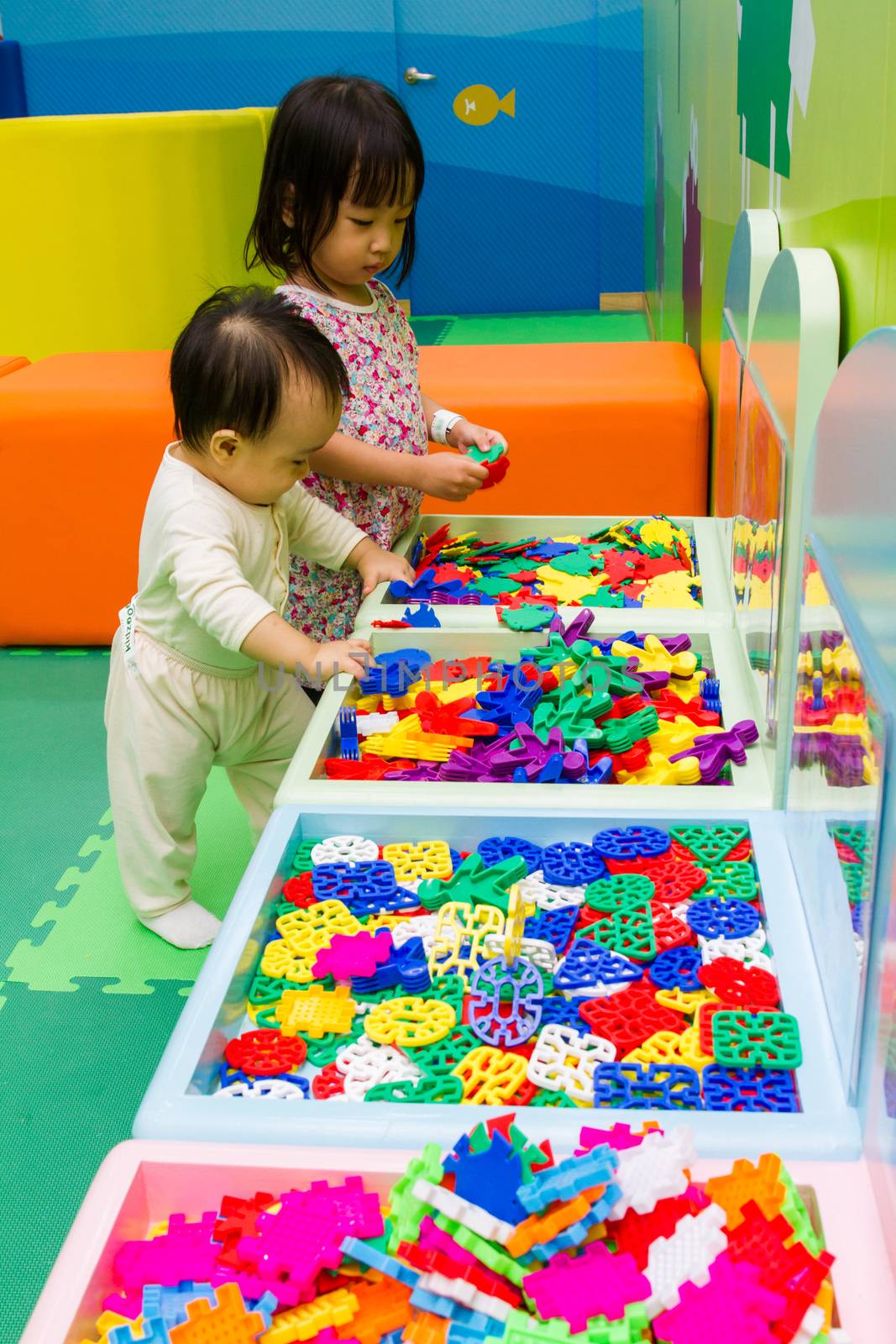 An Asian Chinese childrens playing puzzle at indoor playground.